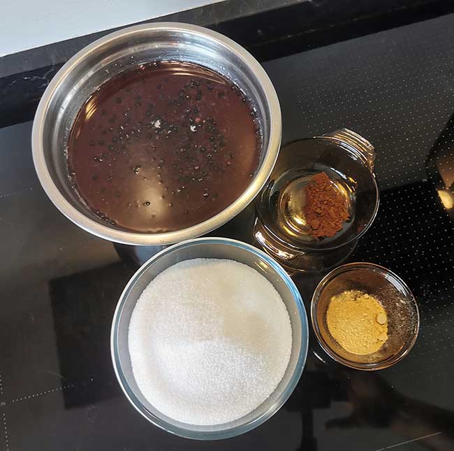 Elderberries, sugar, cloves and ginger ingredients for elderberry syrup on a tabletop